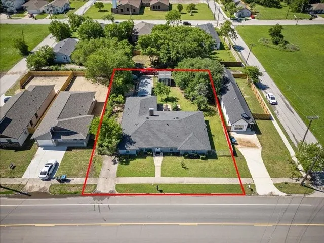 an aerial view of a tennis ground and a cars park side of the road