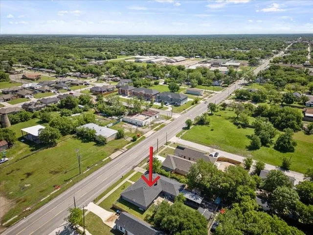 an aerial view of residential houses with outdoor space and trees