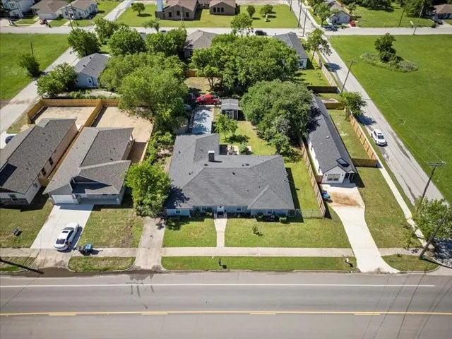 an aerial view of a house with a garden and large trees