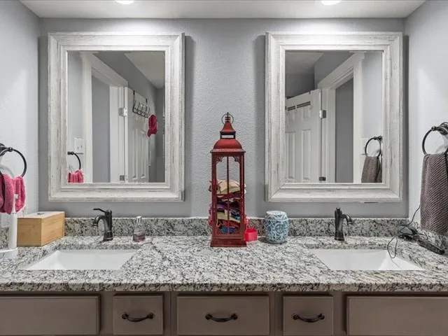 a bathroom with a granite countertop sink vanity and mirror