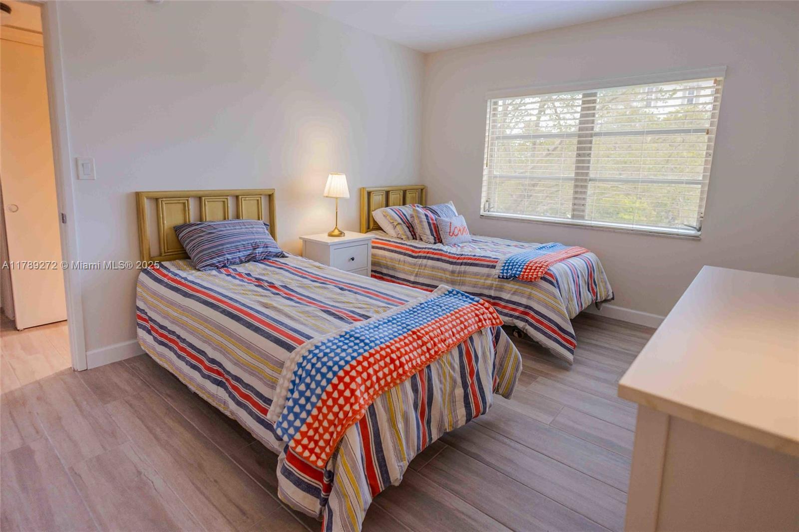 2751 North Palm Aire Drive, Unit 310 Pompano Beach, FL 33069 - Photo 19 of 70 a bedroom with two beds and a window