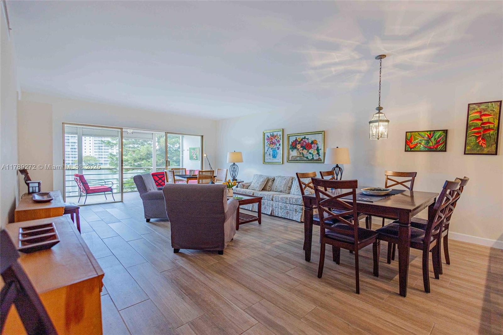 2751 North Palm Aire Drive, Unit 310 Pompano Beach, FL 33069 - Photo 26 of 70 a living room with furniture a rug a dining table and a floor to ceiling window