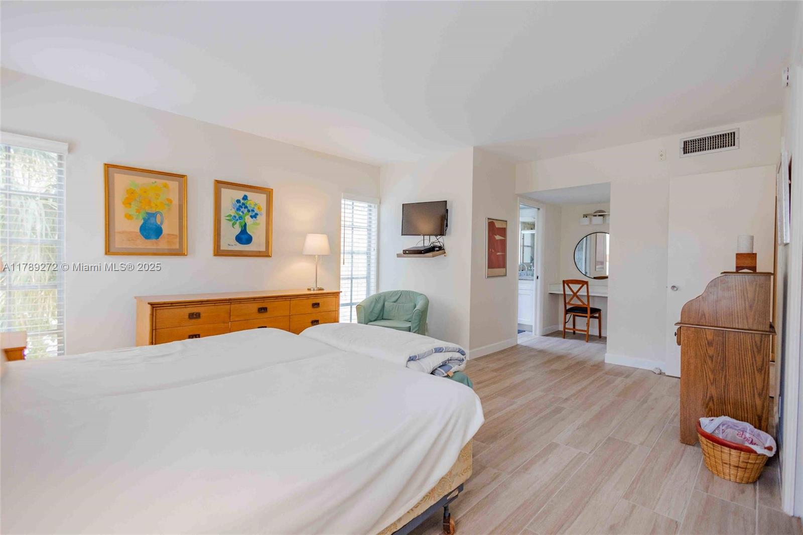 2751 North Palm Aire Drive, Unit 310 Pompano Beach, FL 33069 - Photo 30 of 70 a bedroom with a bed and wooden floor