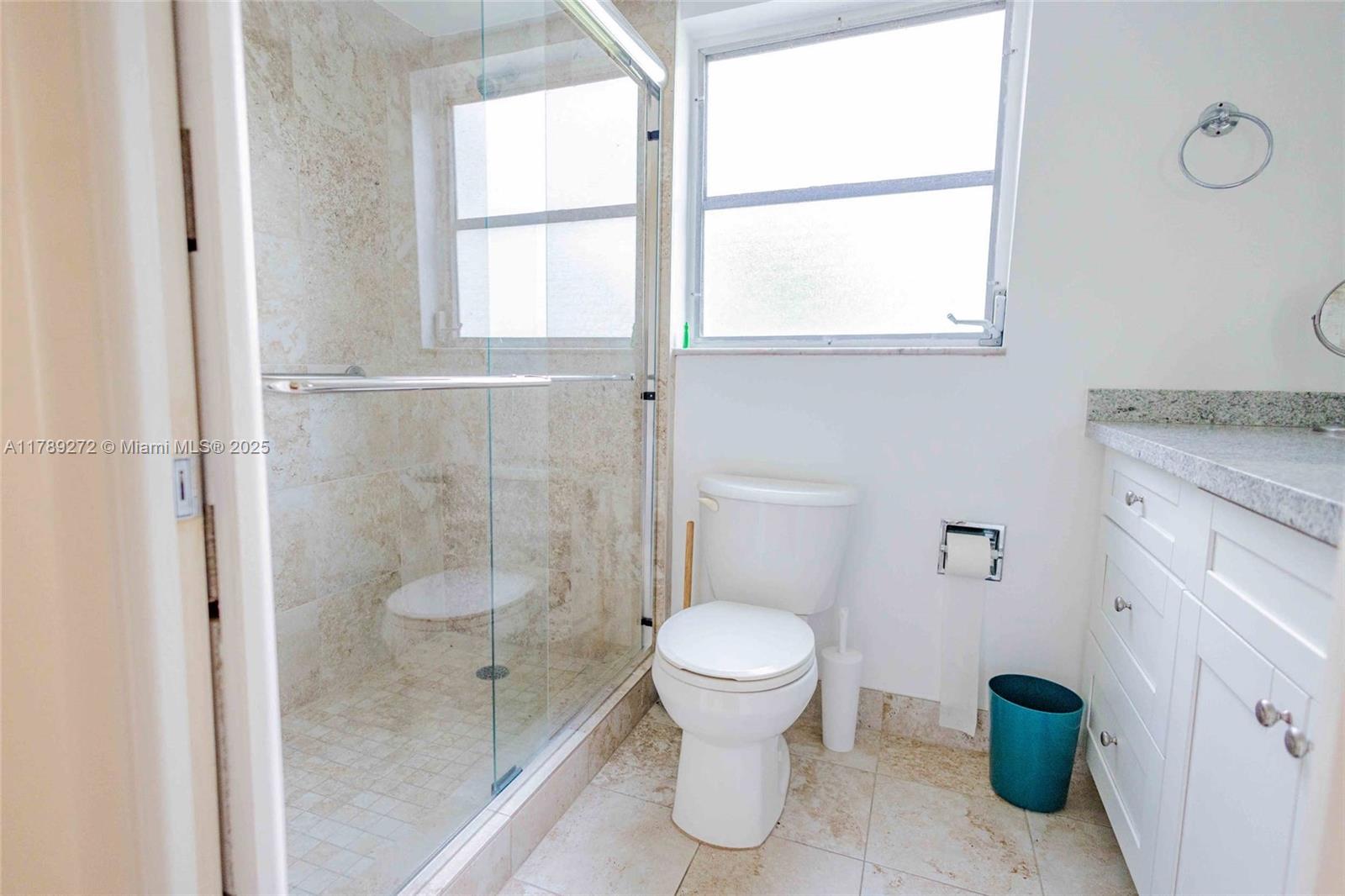 2751 North Palm Aire Drive, Unit 310 Pompano Beach, FL 33069 - Photo 32 of 70 a bathroom with a granite countertop toilet a sink and a shower