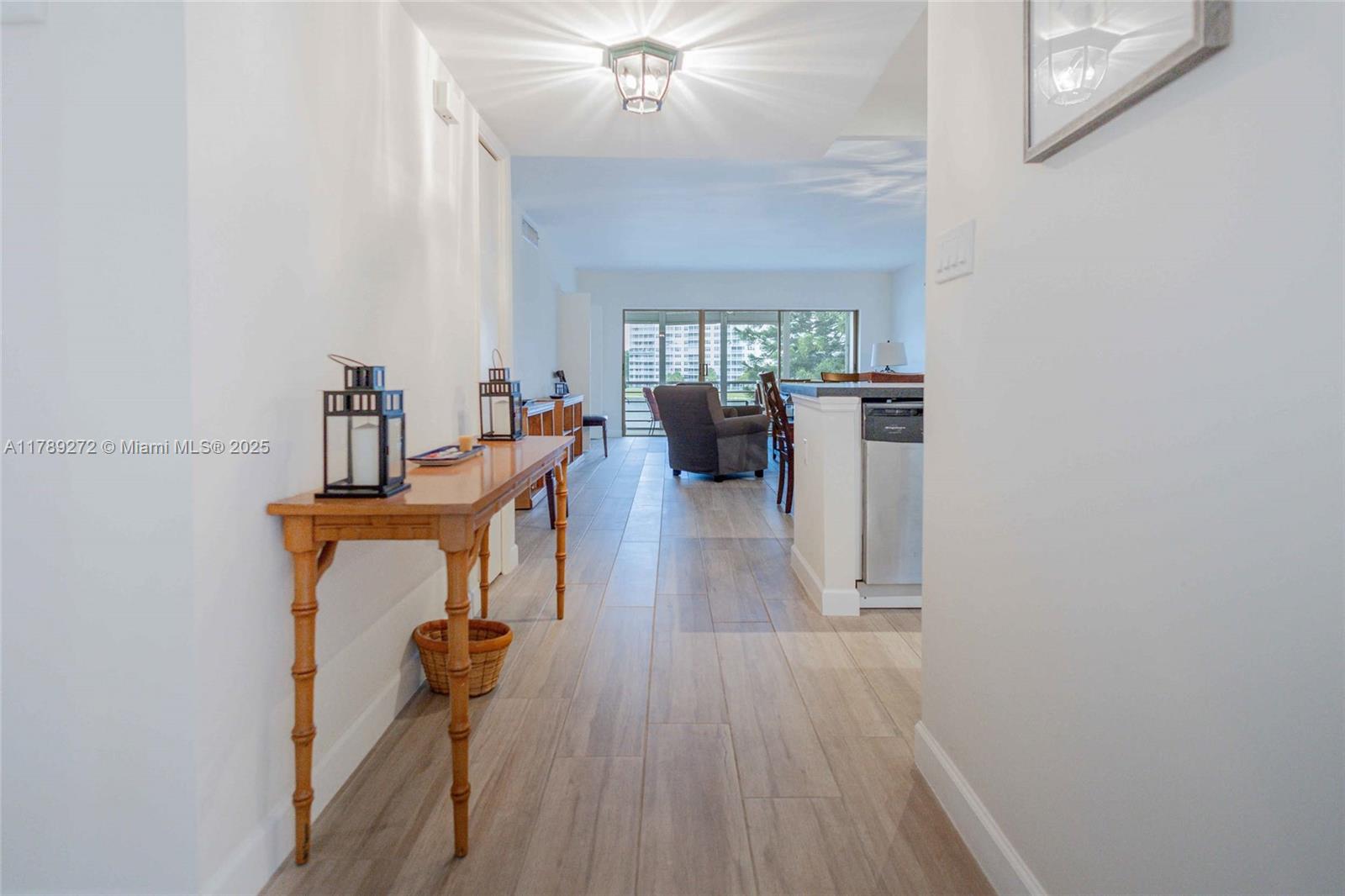 2751 North Palm Aire Drive, Unit 310 Pompano Beach, FL 33069 - Photo 35 of 70 a view of a livingroom with furniture wooden floor kitchen view and a chandelier