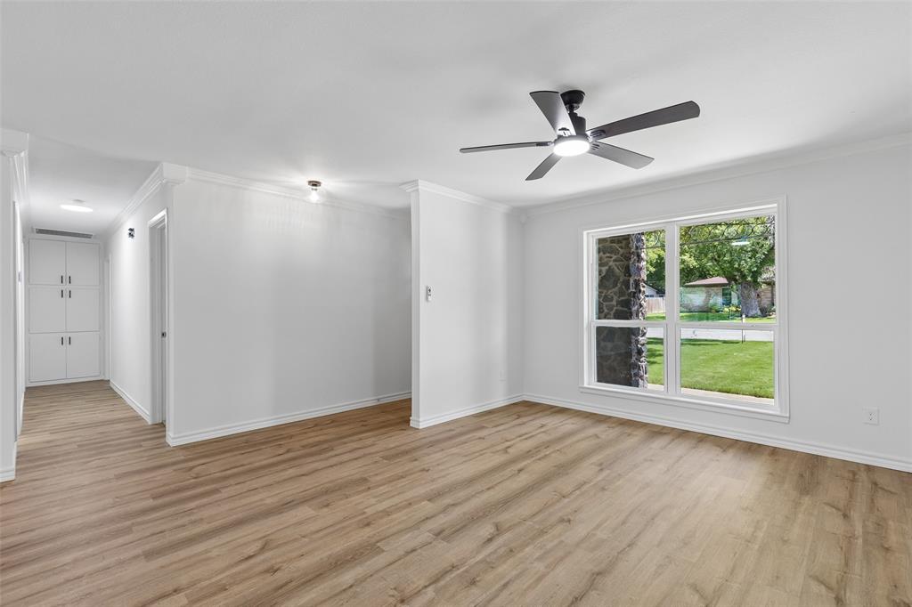 4725 St Lawrence Road Fort Worth, TX 76103 - Photo 15 of 26 Spacious room featuring wood-finish flooring, a contemporary ceiling fan, and a large window with white trim
