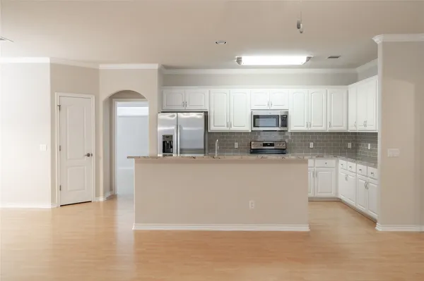a living room with stainless steel appliances granite countertop a stove a sink and a refrigerator