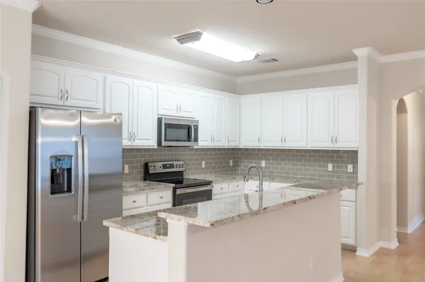 a kitchen with stainless steel appliances granite countertop a refrigerator sink and stove