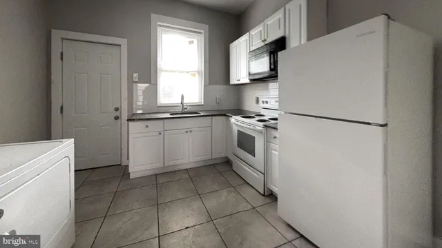 a kitchen with a stove sink and a refrigerator
