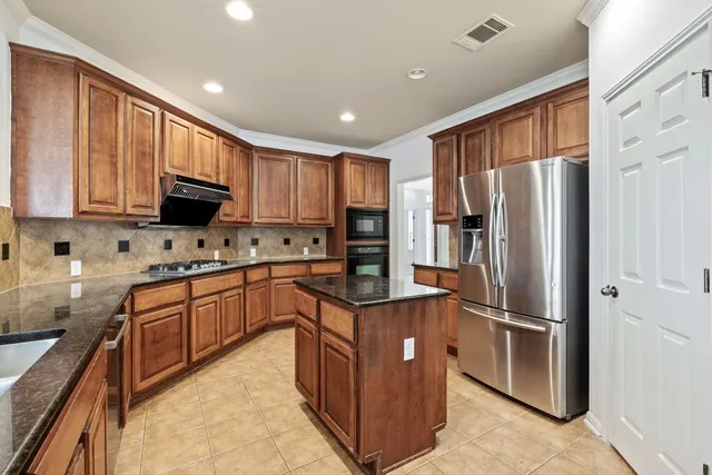 a kitchen with stainless steel appliances granite countertop a refrigerator stove microwave and sink