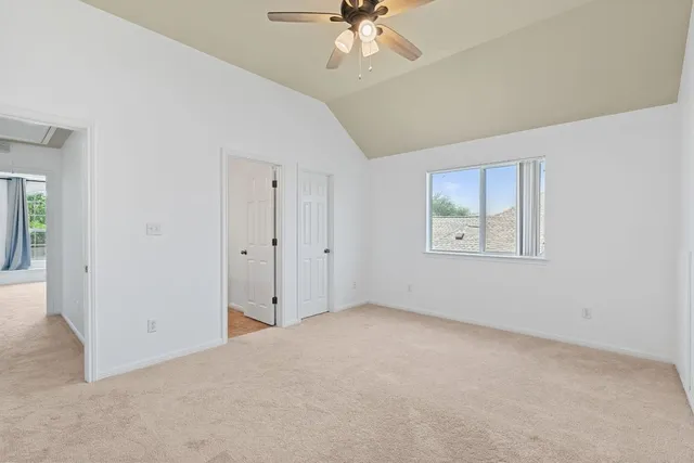 an empty room with fan and windows