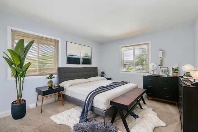 a bedroom with a bed and a potted plant