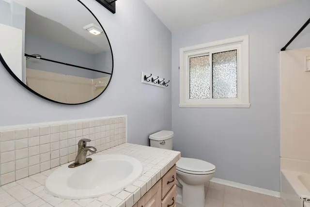 a bathroom with a sink a toilet and mirror