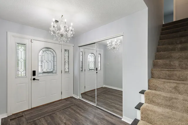 a view of a hallway with wooden floor and staircase