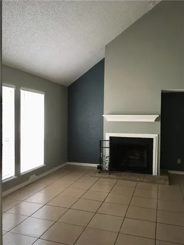 a view of an empty room with a fireplace and a window