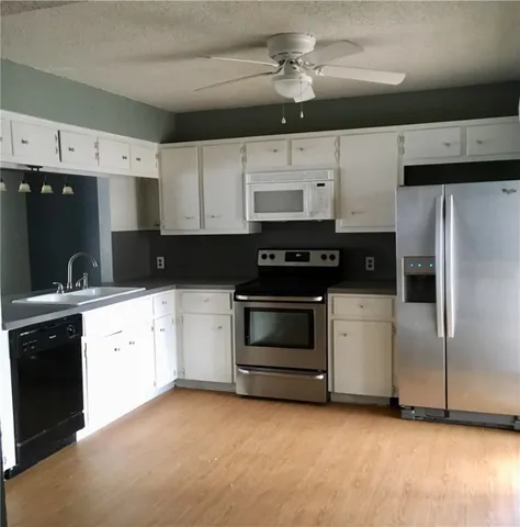 a kitchen with a refrigerator stove and white cabinets