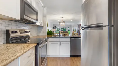 a kitchen with a sink a refrigerator and wooden floor