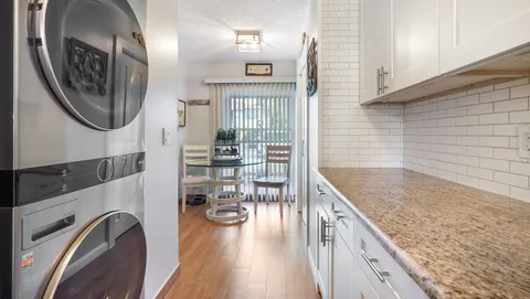 a kitchen with granite countertop a sink a stove and cabinets