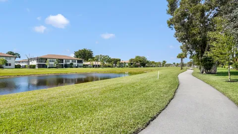 a view of a lake with a yard and large trees