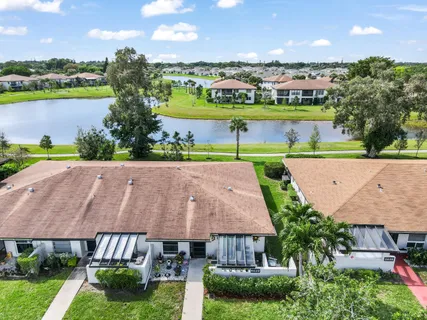 an aerial view of a house with a garden and lake view