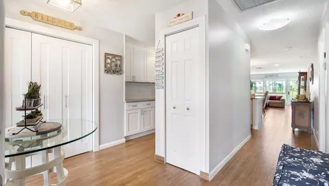 a view of a hallway with wooden floor and a living room