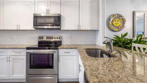 a kitchen with stainless steel appliances granite countertop a sink a stove a microwave and cabinets
