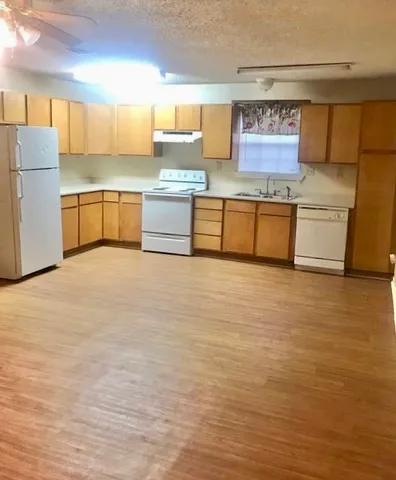 a large kitchen with stainless steel appliances a sink and a refrigerator