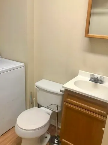 a white toilet sitting next to a sink and vanity