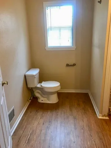 a bathroom with a toilet and a window