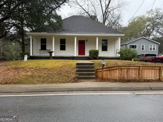 a front view of house with yard and trees around