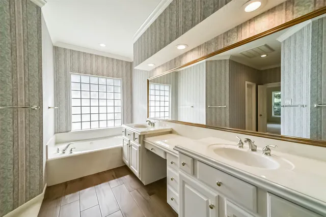 a bathroom with a sink double vanity granite tub shower and a mirror