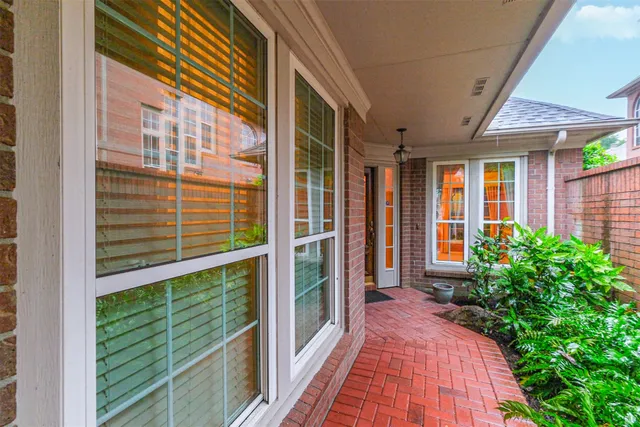 a view of a balcony with a floor to ceiling window and potted plants