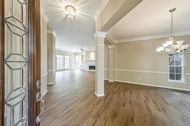 a view of a hallway with wooden floor and a chandelier