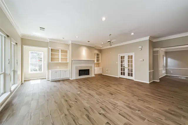 an empty room with wooden floor and fireplace