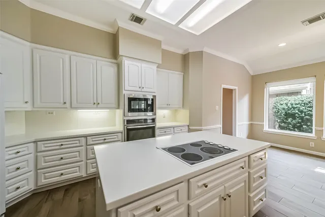a kitchen with granite countertop white cabinets and white appliances