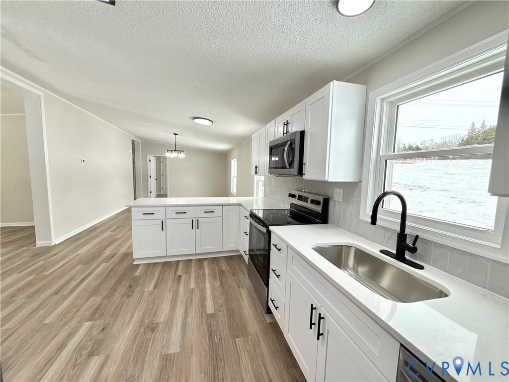 1500 Webster Road Glade Hill, VA 24092 - Photo 11 of 22 a large white kitchen with a sink a counter top space stainless steel appliances a window and a sink