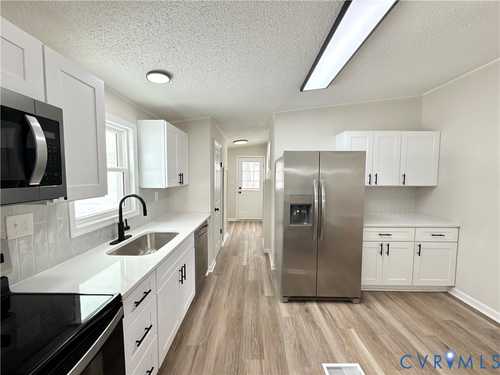 1500 Webster Road Glade Hill, VA 24092 - Photo 9 of 22 a kitchen with stainless steel appliances granite countertop a refrigerator a sink a stove and white cabinets