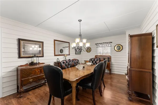 a view of a dining room with furniture a chandelier and wooden floor