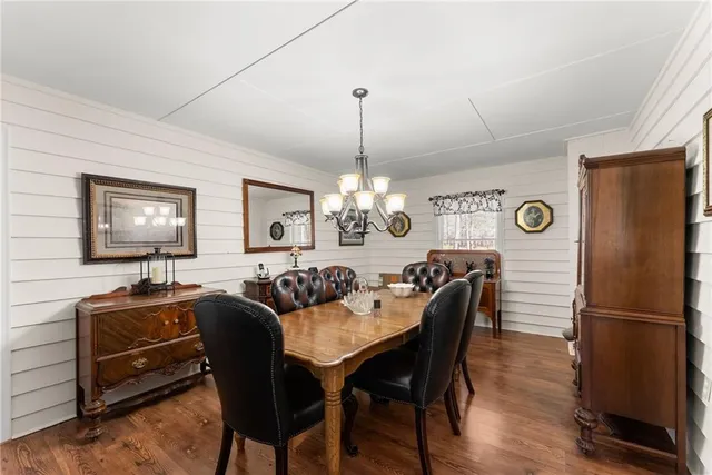 a view of a dining room with furniture a chandelier and wooden floor