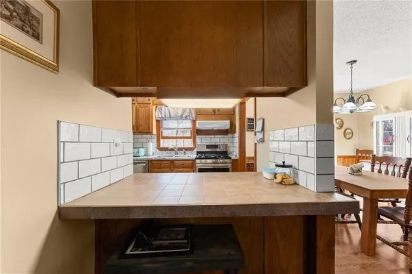 a kitchen with stainless steel appliances granite countertop a stove a sink and a refrigerator