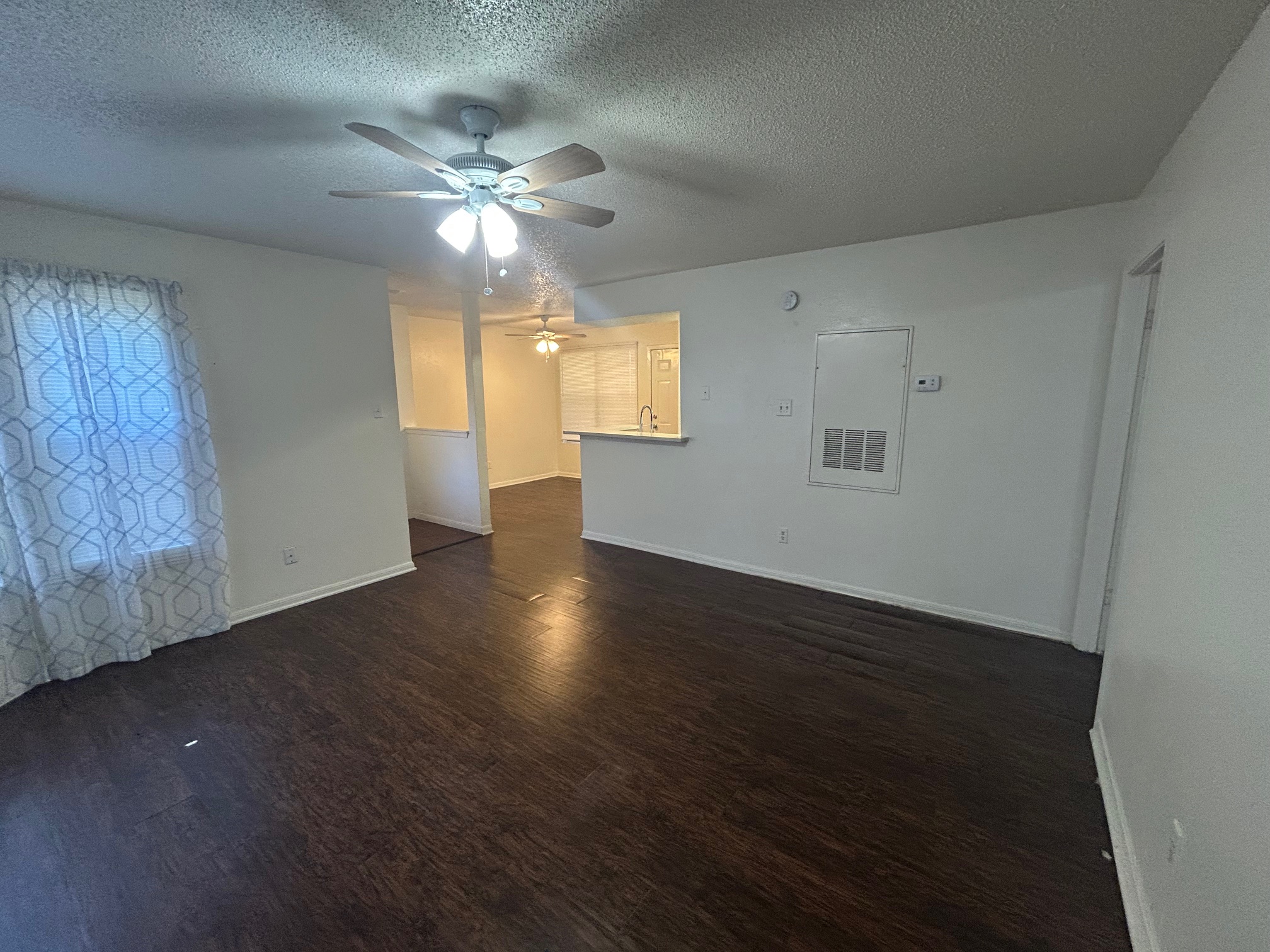 8812 Schick Road, Unit C Austin, TX 78729 - Photo 7 of 12 Spare room featuring dark wood-style flooring, a textured ceiling, and ceiling fan