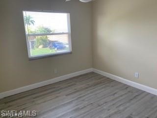 8313 Matanzas Road Fort Myers, FL 33967 - Photo 13 of 17 an empty room with wooden floor and windows