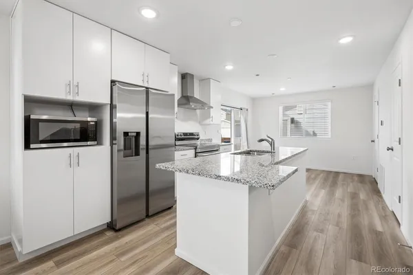 a kitchen with stainless steel appliances granite countertop a refrigerator and a sink