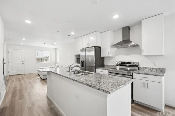 a kitchen with stainless steel appliances granite countertop a sink stove and refrigerator