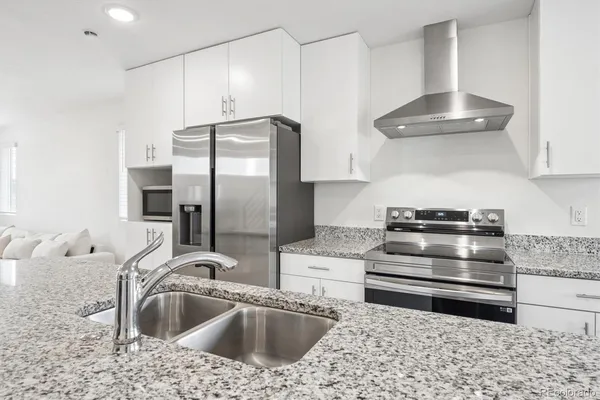 a kitchen with stainless steel appliances a stove a sink and a refrigerator