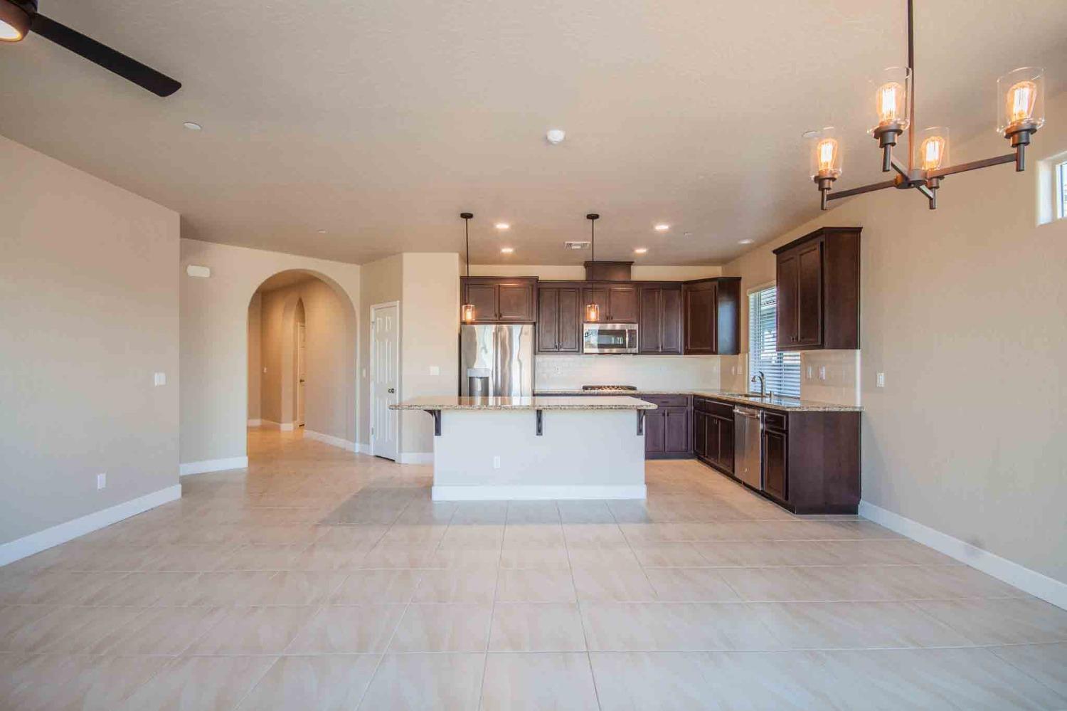 3439 Brimhall Lane Clovis, CA 93619 - Photo 13 of 43 a view of a kitchen with kitchen island a sink a counter top space stainless steel appliances and cabinets