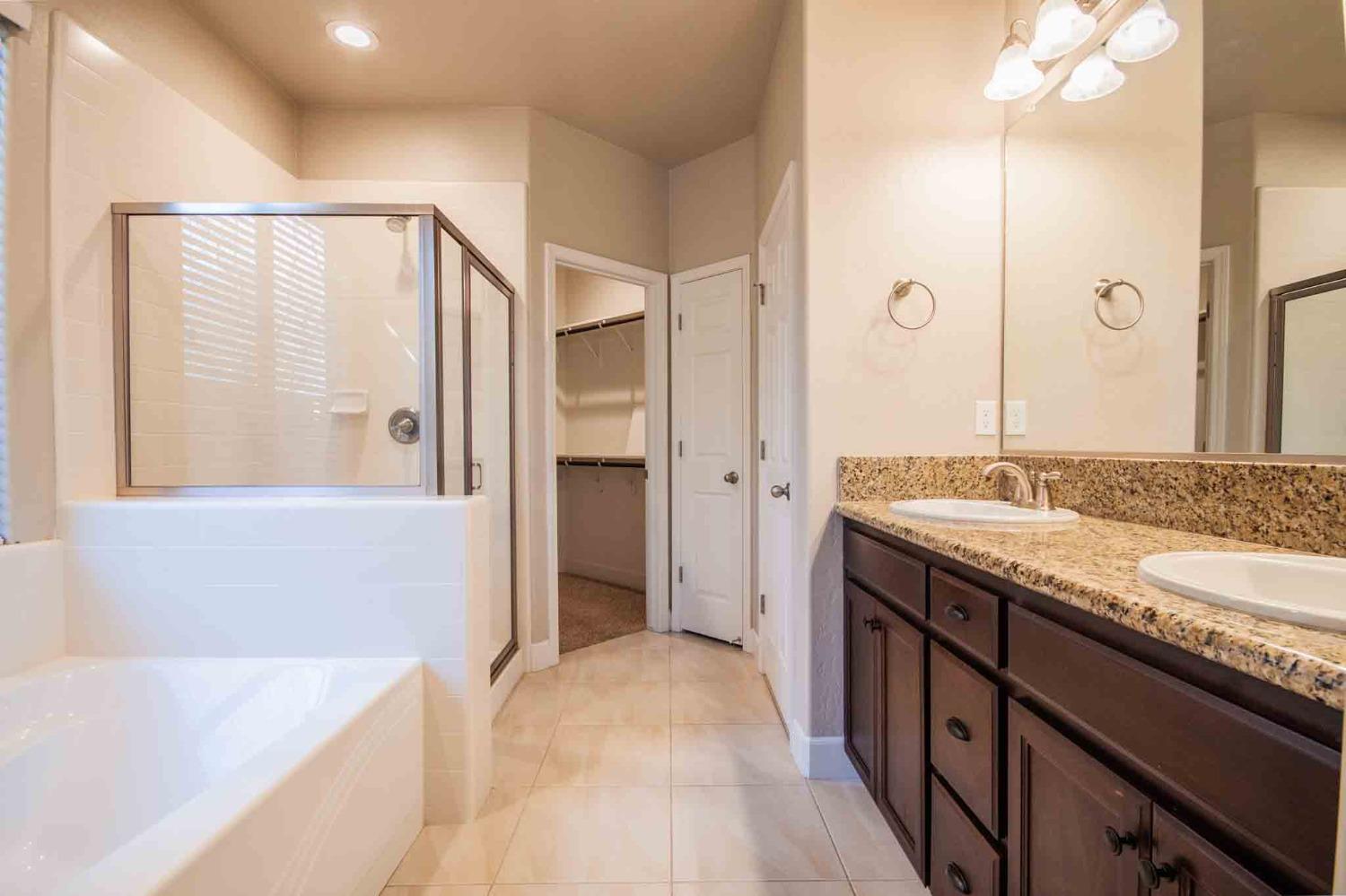 3439 Brimhall Lane Clovis, CA 93619 - Photo 21 of 43 a spacious bathroom with a granite countertop sink and a mirror