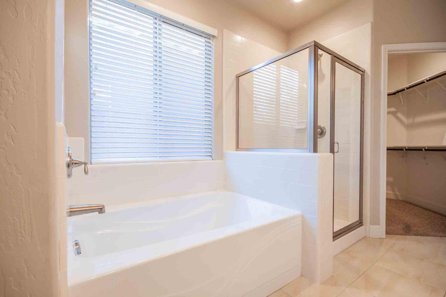 3439 Brimhall Lane Clovis, CA 93619 - Photo 22 of 43 a bathroom with a bathtub and a shower