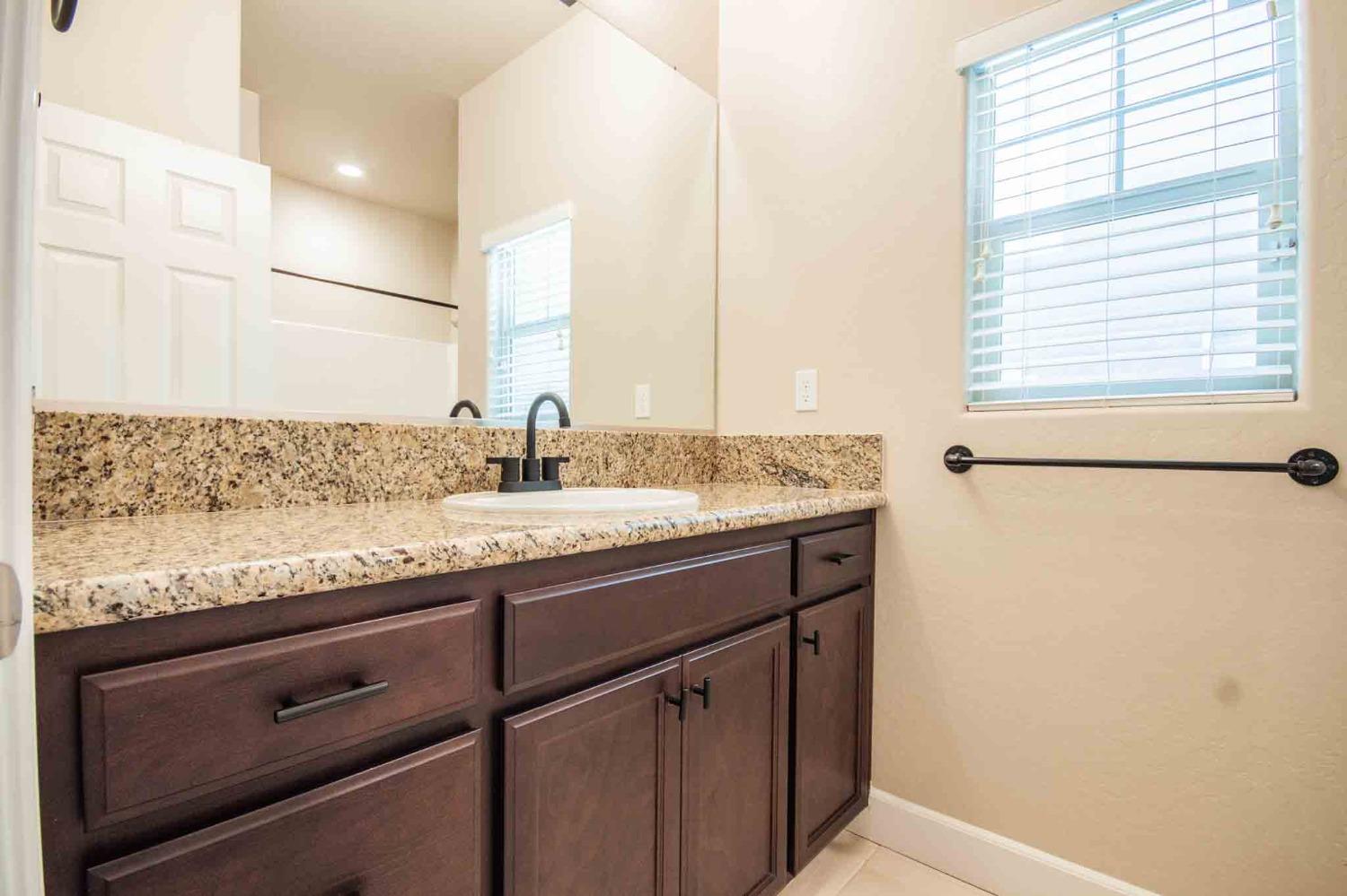 3439 Brimhall Lane Clovis, CA 93619 - Photo 28 of 43 a bathroom with a granite countertop sink and a mirror