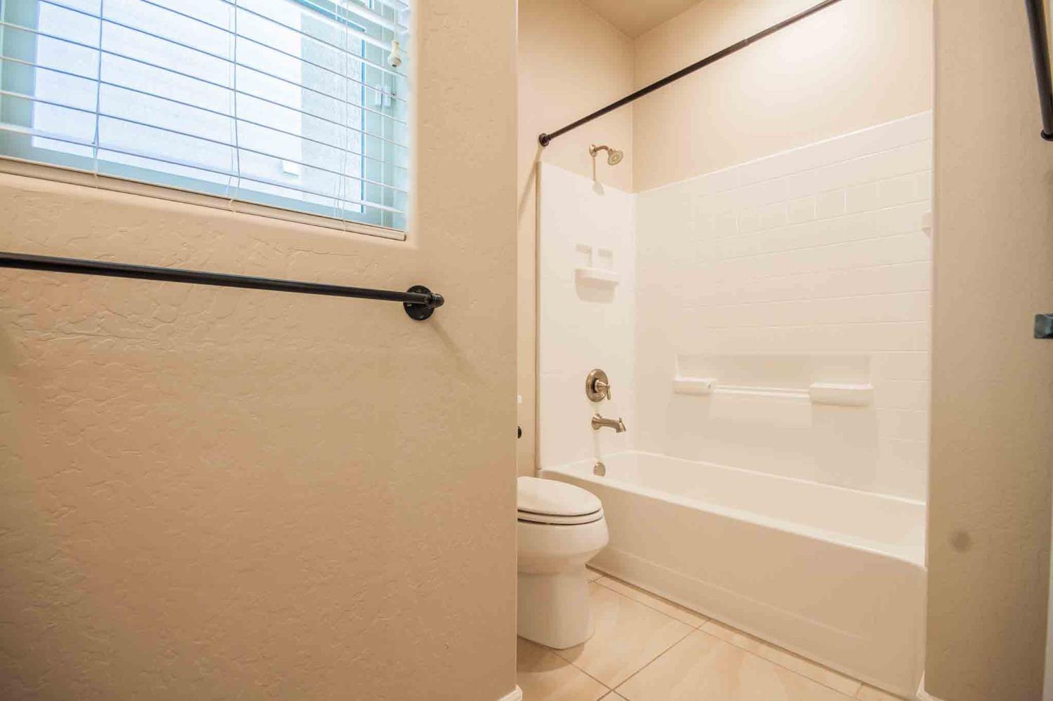 3439 Brimhall Lane Clovis, CA 93619 - Photo 29 of 43 a bathroom with a granite countertop bathtub shower sink vanity and toilet
